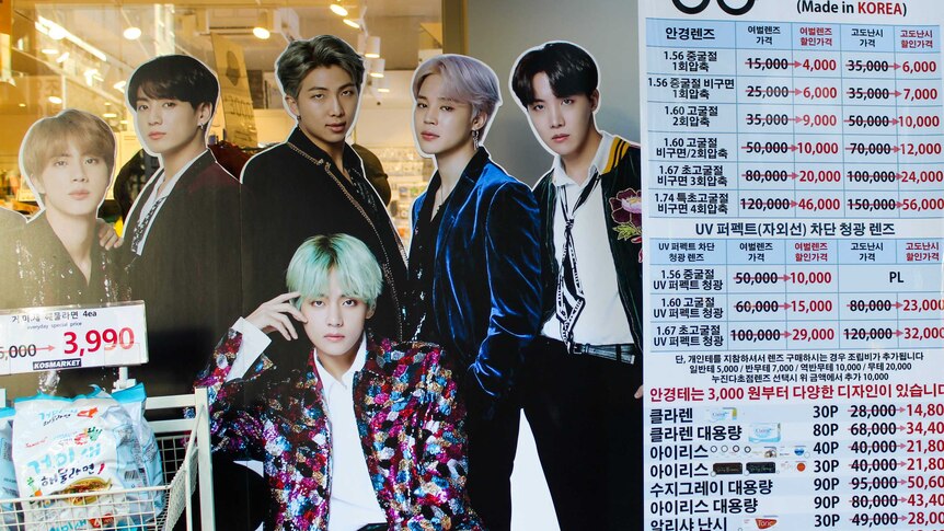 Cosmetics list in Korean and K-pop poster in shopfront in Seoul in 2019.