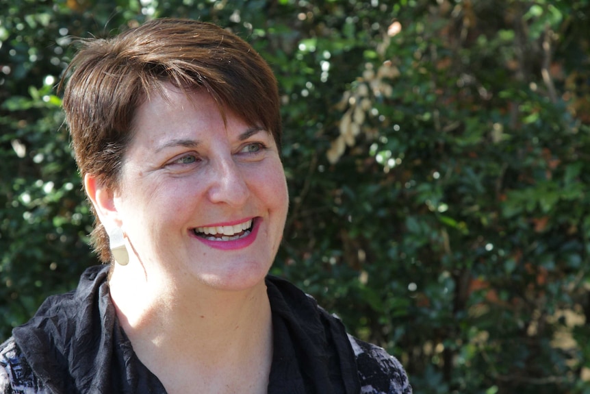 A close-up of woman Melissa Green smiling and looking away from the camera