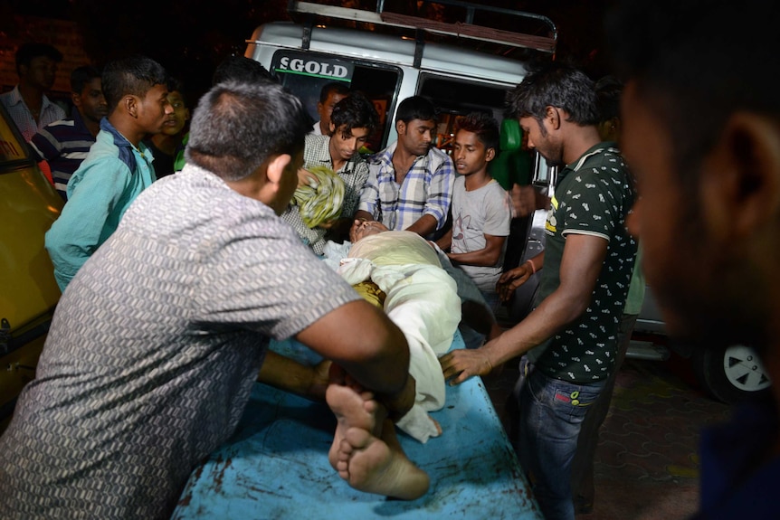 Indian staff at Siliguri Hospital help a victim injured during the earthquake.