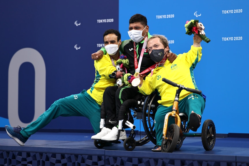 Los medallistas australianos Ahmed Kelly y Grant Patterson están a ambos lados de Jesús Hernández en el podio de los Juegos Paralímpicos.