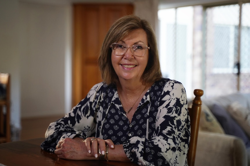 Karenne smiles at kitchen table.