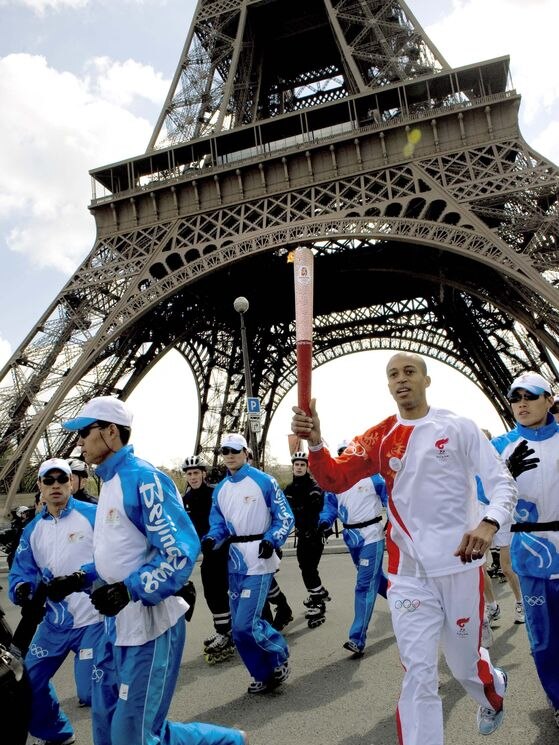 French athlete Stephane Diagana runs with the Olympic torch