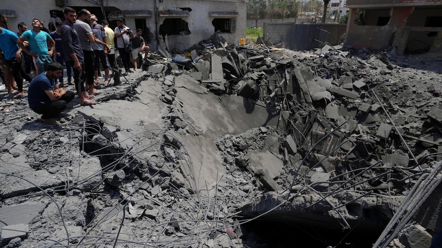 Residents inspect the rubble of destroyed residential building which was destroyed by Israeli airstrikes.