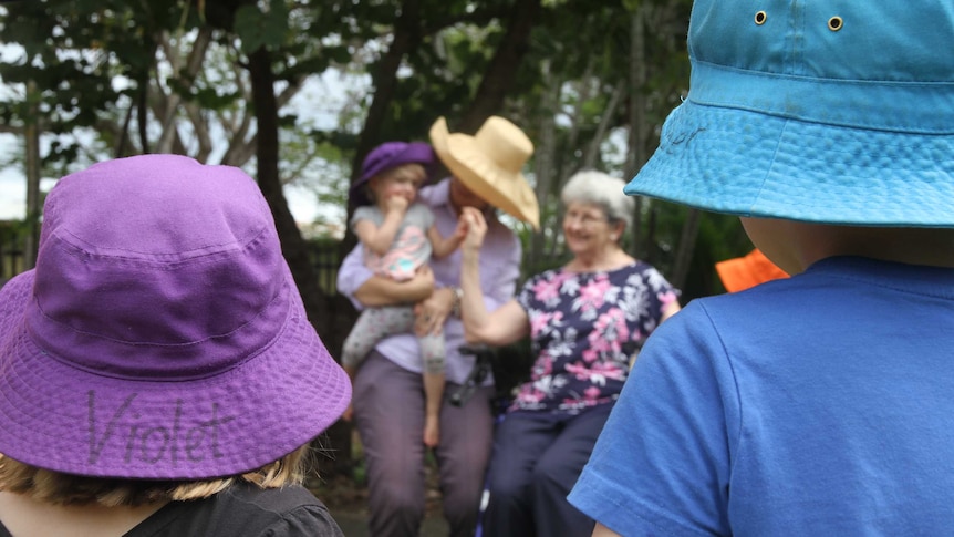 Aged care resident Noela Kelly meets some young children at Elfin House community child care centre