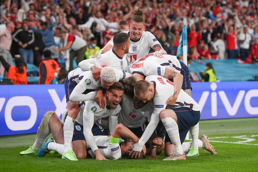 A number of England players pile on top of Harry Kane in celebration