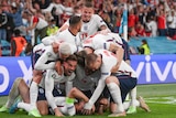 A number of England players pile on top of Harry Kane in celebration