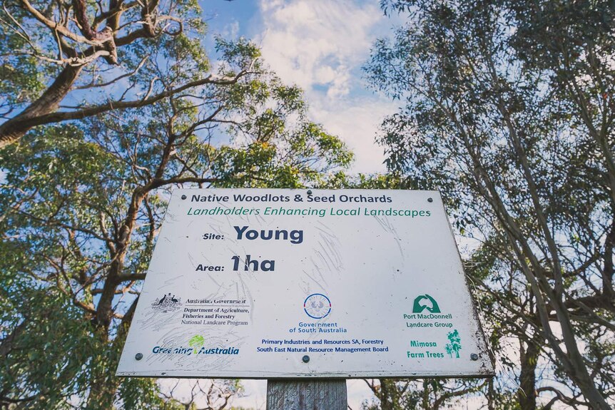 A government authorised sign surrounded by trees reads 'Landholders Enhancing Local Landscapes. Site, Young. Area, one hectare.'