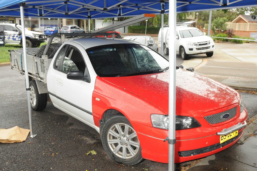 A white ute with red panelling on the front.