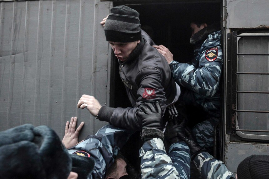 Russian police detain a protester in Volgograd.