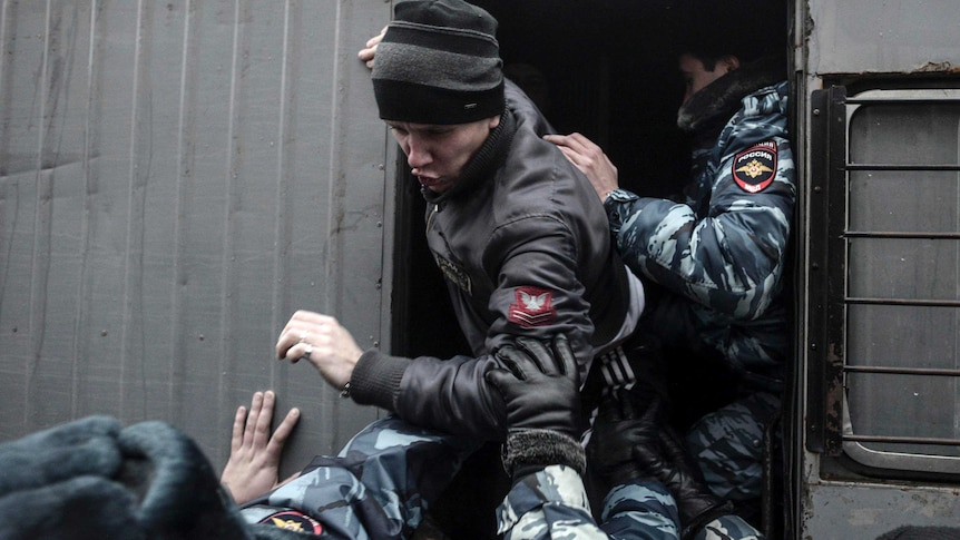 Russian police detain a protester in Volgograd.