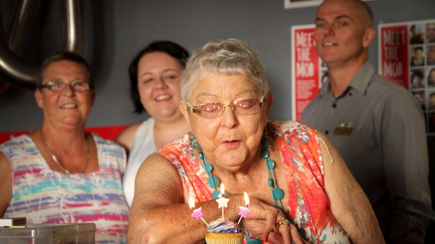 Pauline Haynes blows out a candle on a cupcake.