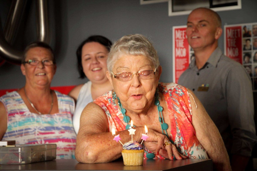 Pauline Haynes blows out a candle on a cupcake.