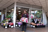 A woman standing outside a flower store