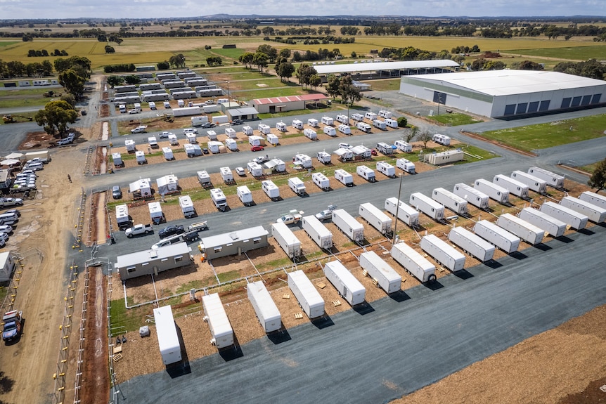 A drone photo of caravans neatly set in a large field.