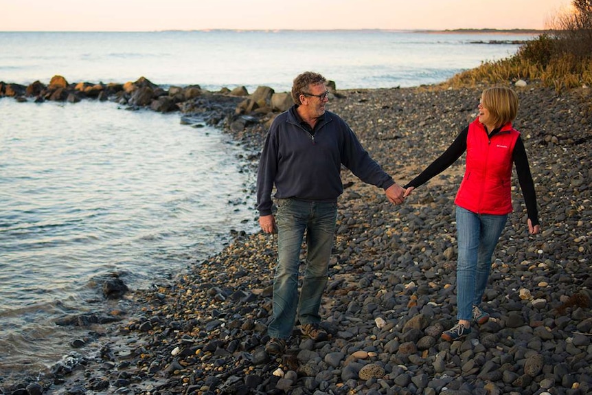 Matthew and Julie Coope walking on a rocky beach, Tasmania 2019.
