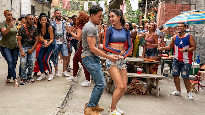 Anthony Ramos and Melissa Barrera, a young Latinx couple dancing in the street, In The Heights 