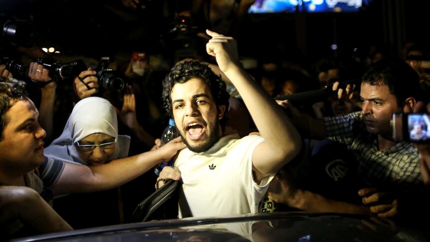 Abdullah Al-Shamy gestures as he speaks to the media after being released from detention.