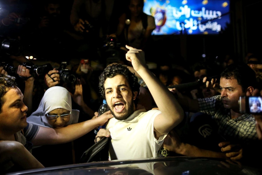 Abdullah Al-Shamy gestures as he speaks to the media after being released from detention.