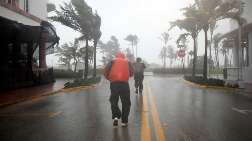 People walk along a street in South Beach as Hurricane Irma arrives at south Florida.