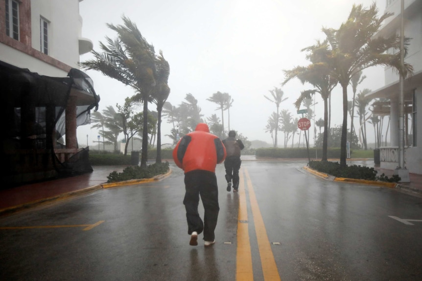 People walk along a street in South Beach as Hurricane Irma arrives at south Florida.