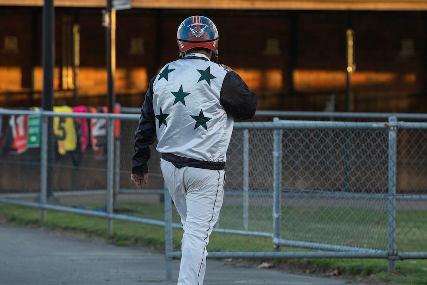 A man in a silk shirt with stars on it faces away.