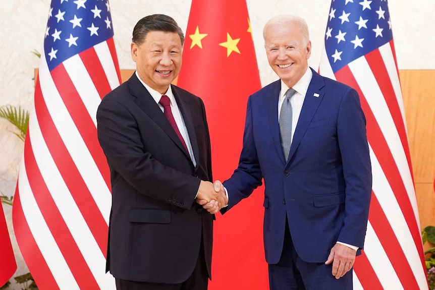 Joe Biden shakes hands with Xi Jinping.