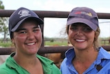 two women standing in front of cattle yards
