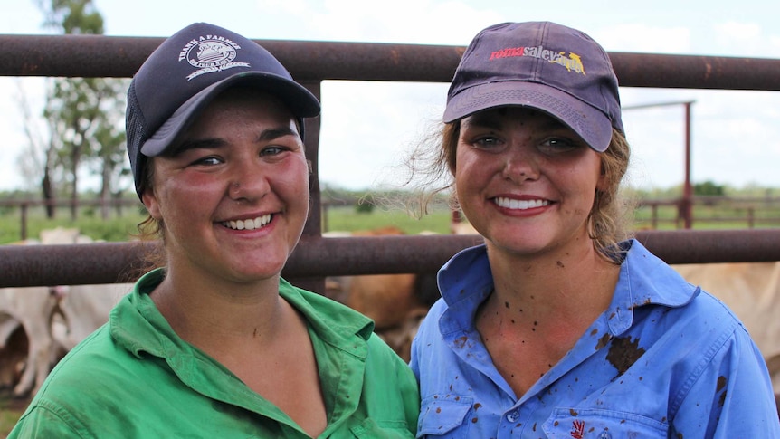 two women standing in front of cattle yards