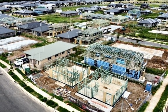 Aerial shot of several houses under construction alongside newly built homes.