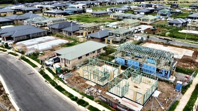Aerial shot of several houses under construction alongside newly built homes.