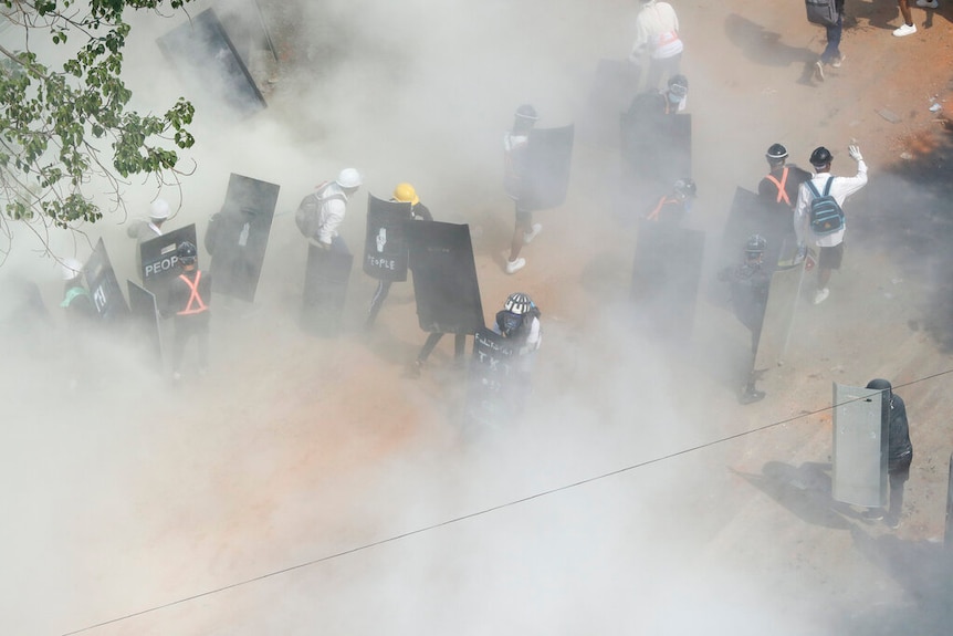 Police fire tear gas on protesters during an anti-coup demonstration in Yangon, Myanmar