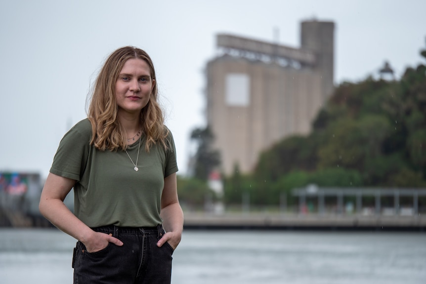 Jaclyn McCosker standing near the centre of Gladstone with silos in the background, November 2021.