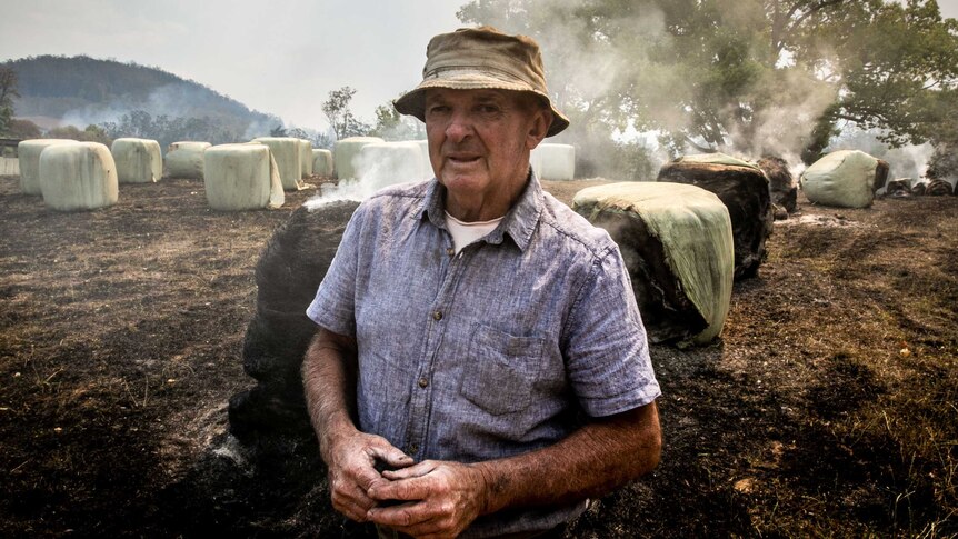 A man in front of a burning field.