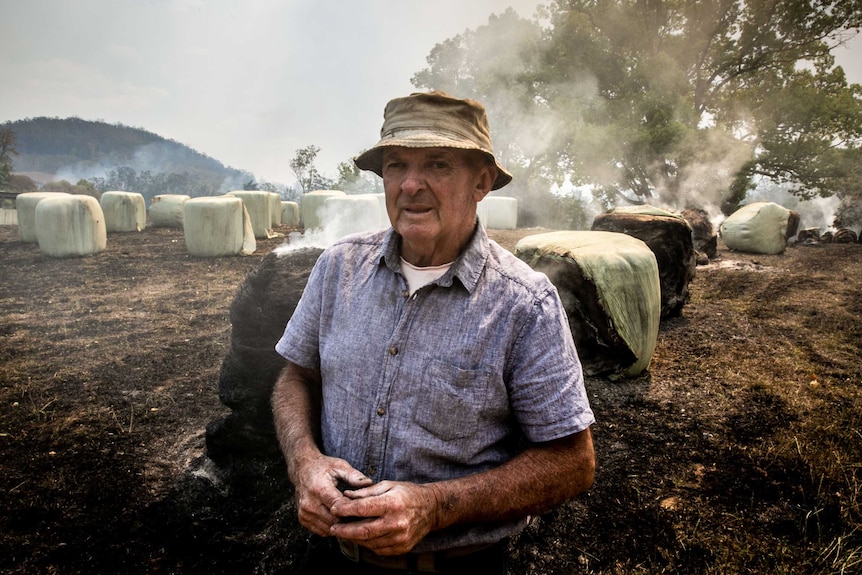 A man in front of a burning field.