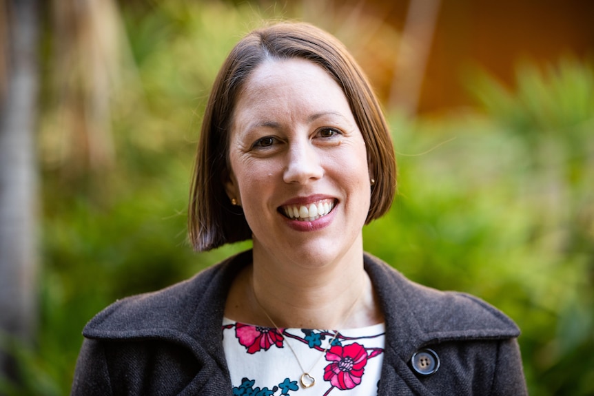 A woman with brown hair smiling at the camera.