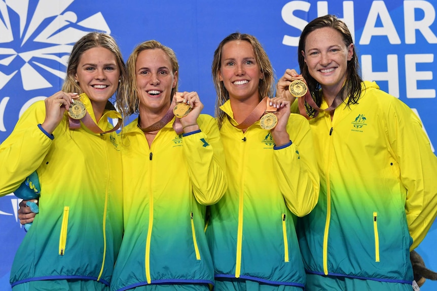 The Australian women's relay team holds their gold medals on the podium