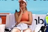 Daria Saville looks frustrated sitting on her bench