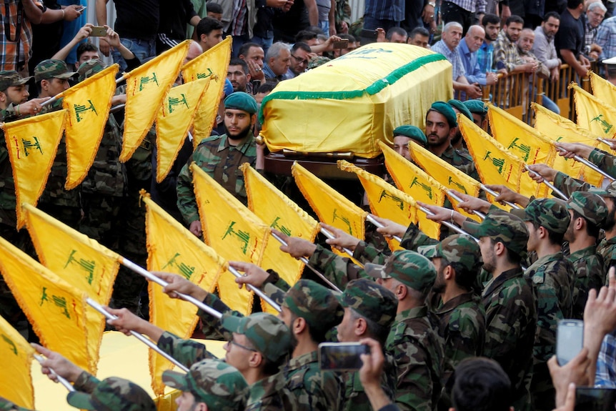 Hezbollah members carry the coffin of top Hezbollah commander Mustafa Badreddine