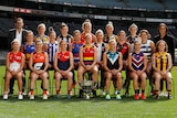 Photo of all 18 AFLW club captains plus Travis Auld and Nicole Livingstone from the AFL. Players are seated at Marvel stadium