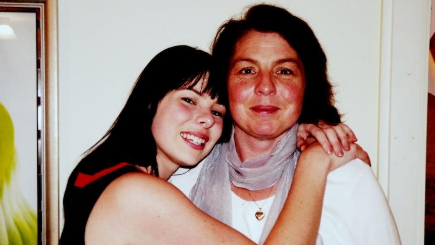 A picture of a girl and an older woman hugging and posing for a photo