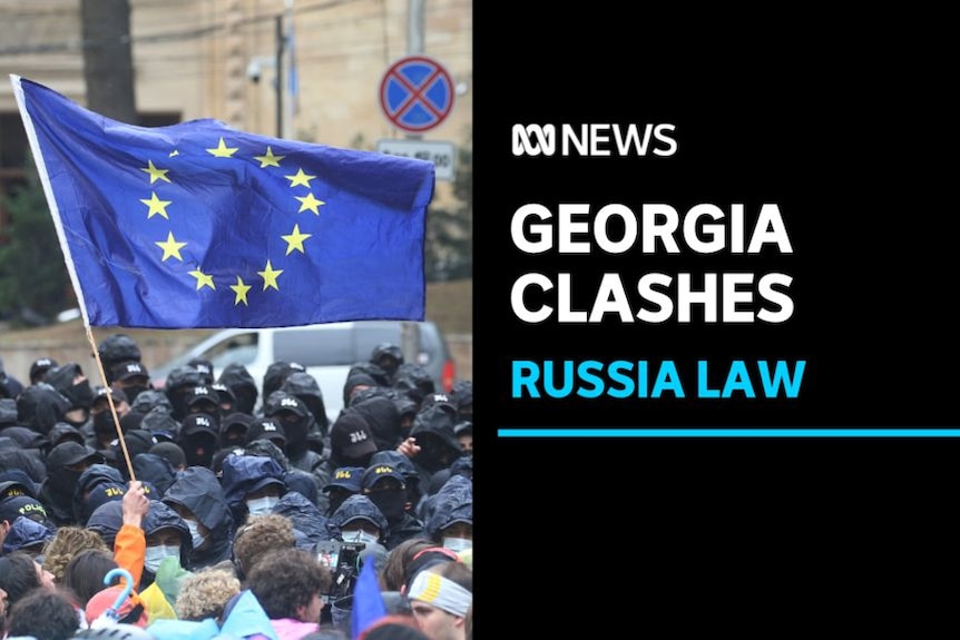 Georgia Clashes, Russia Law: An EU flag is waved as protesters face off with police during protests.