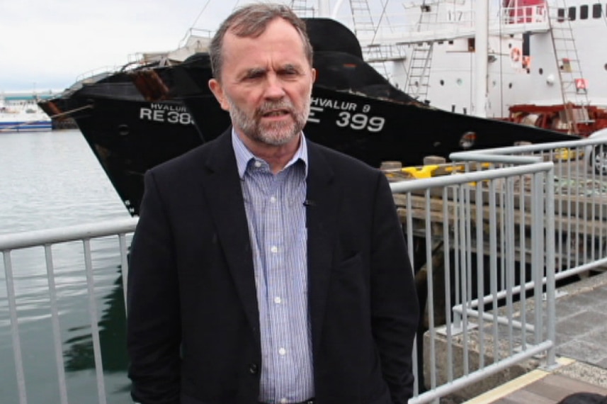 A shot of Kristjan Loftsson from the waist up, standing in front of a boat on the docks in Reykjavik.