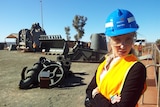 Veronica Macpherson in Newman wearing a blue hard hat and high-visibility orange vest.