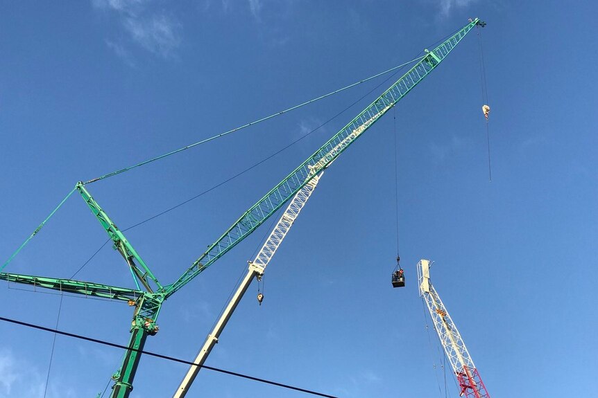 Two cranes are used to dismantle a damaged crane at the Richmond worksite.