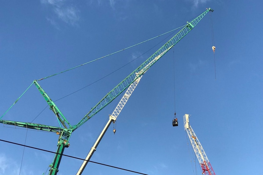 Two cranes are used to dismantle a damaged crane at the Richmond worksite.