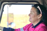 Heather Jones with her hand on the steering wheel driving a truck