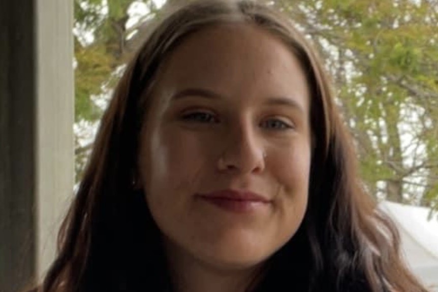 A smiling young woman with long dark hair.