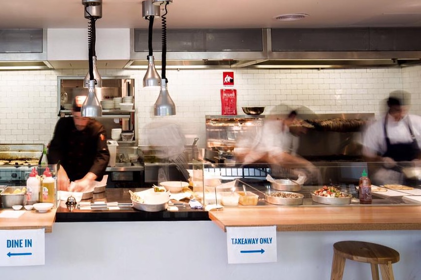 Three men work in a restaurant kitchen.