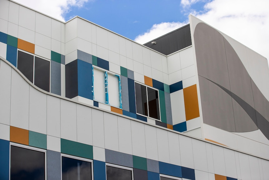 A close up of a white building with colourful panels.