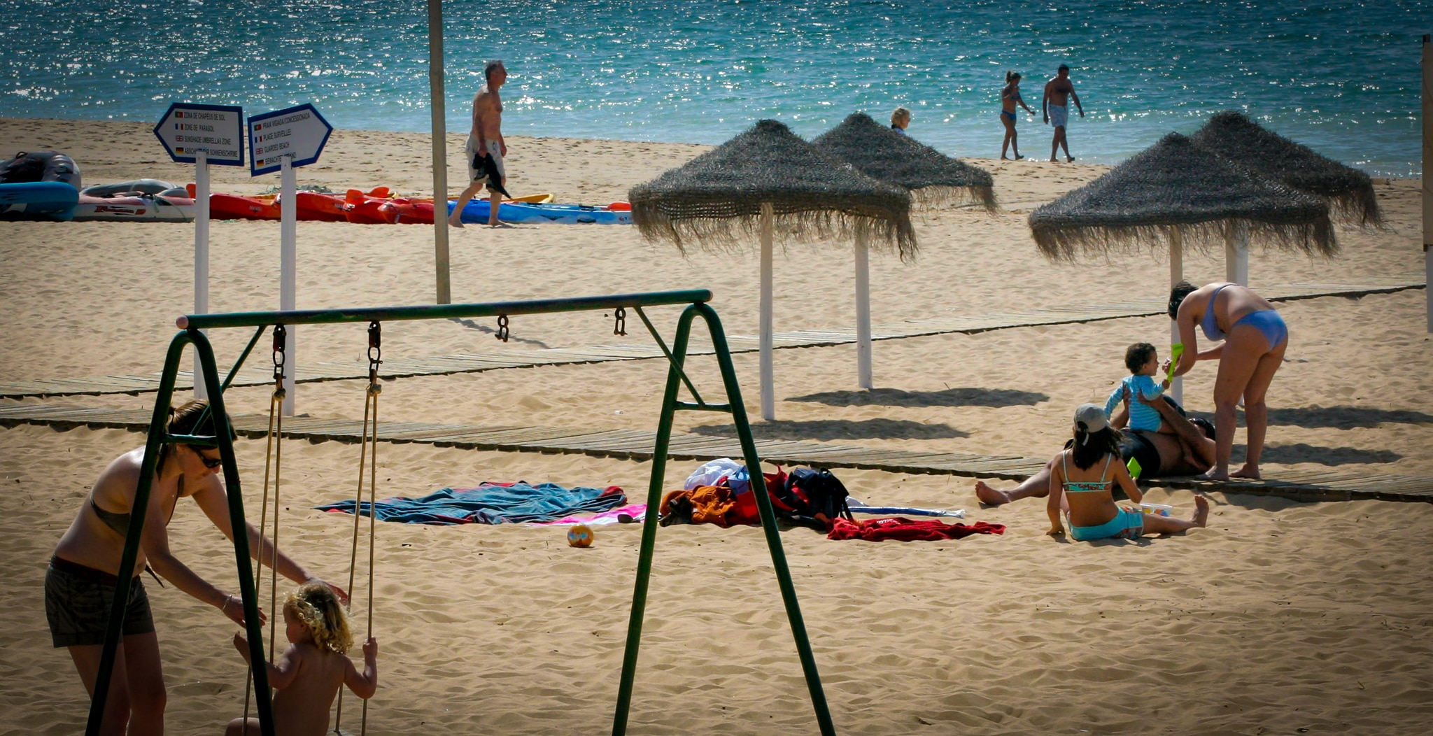 Women play with their children on a beach 